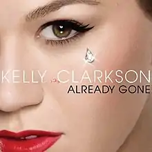 The left side of the face of a woman of white complexion. She is wearing mascara and a red lipstick. Near her eye a shiny drop is seen. In front of her image the words "Kelly Clarkson" are written in white capital letters, while the words "Already Gone" are written in black capital letters.