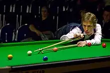 Ken Doherty playing a shot with the rest