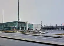 A photo of a glass panelled light rail station with the name "Kennedy" in bold white lettering on the side. The structure is mostly completed, but signage over the entrances has not yet been added.