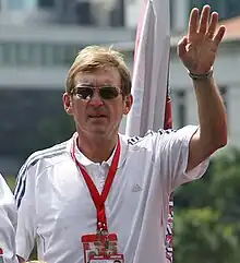 Kenny Dalglish in a white shirt, wearing sunglasses.