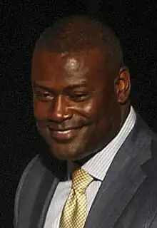 Color head-and-shoulders photograph of smiling African-American man (Kevin Carter) in suit and tie.