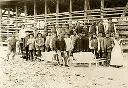 1913: Staff at the Neuohe factory, with male workers and a female cook in front of a drying shed