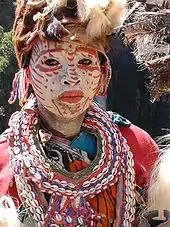 A Kĩkũyũ woman in traditional dress. Ceremonial face painting.