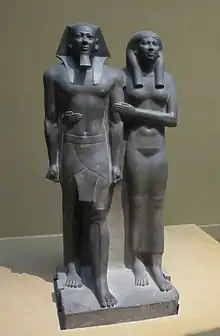 Menkaura (Mycerinus) and queen, Old Kingdom, Dynasty 4, 2490–2472 BCE. The formality of the pose is reduced by the queen's arm round her husband