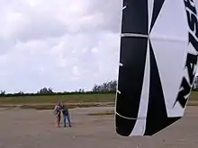 A quad-line traction kite, commonly used as a power source for kite surfing. Application: sport, recreation, exercise, rest, product demonstration.