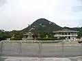 Monument on the road in front of the Blue House, administrative building in the background