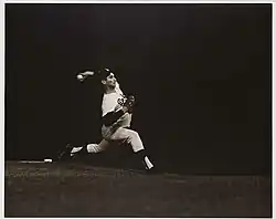 a baseball pitcher on the mound and in full-stride, throwing towards homeplate