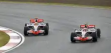 Two cars going around a corner