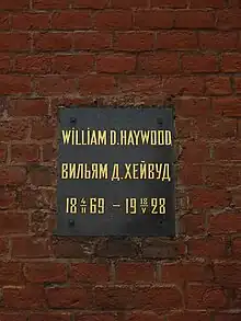 Plaque on a brick wall with inscription: William D. Haywood/Вильям Д. Хейвуд, 1869-02-04–1928-05-18