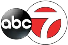 A white 7 in a white circle with red fill, trimmed in black. The ABC network logo, a black disk with lowercase letters a b c, overlaps it on the left side.