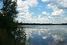 Clouds reflected in lake, IDS tower and downtown visible in the distance