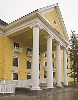 Yellow building with four-column portico