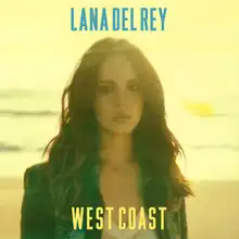 A yellow-filtered portrait of a brunette woman wearing a denim jacket, standing on a beach with waves as her backdrop. In bold blue font above her is the name Lana Del Rey. Below her in bold yellow font is the title "West Coast".