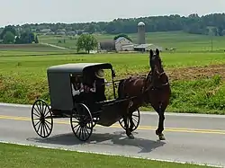 An Amish family in a horse-drawn square buggy in Lancaster County, Pennsylvania, United States