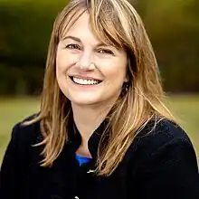 Blond white woman wearing black jacket