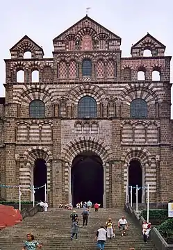 A highly ornamental church façade built in alternating courses of red and white stone.