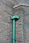 Drain pipe header. Between the letters St. and T  is a square to symbolise the apostle as a 'builder.'