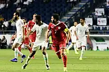 Hassan Maatouk and a Saudi player running while looking in the same direction