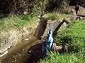 The headwaters of the  Water of Leith are diverted around Sullivan's Dam in a series of concrete water races