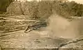 Splash of logs being dumped into a log pond.