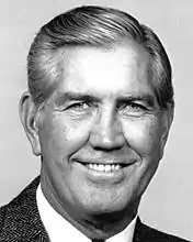 Posed black and white headshot of Carpenter wearing a dark suit