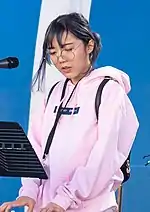 photograph of lilypichu playing the piano at a twitch concert