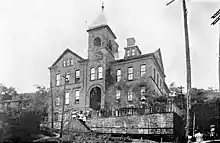  Lincoln School Wheeling, West Virginia, with people lining a fence in front of it