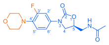 Skeletal formula of N-{[(5S)-3-[3-fluoro-4-(morpholin-4-yl)phenyl]-2-oxo-1,3-oxazolidin-5-yl]methyl}acetamide, highlighting the morpholino and fluoro groups in orange, with the rest in blue. The carbon atoms of the parent chain are numbered.