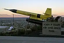 The black and yellow missile sits on display overlooking desert and mountains of New Mexico