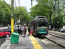 A light rail train at a surface station with no canopies