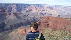 View from southwest,(5.5-mi distant, from Pima Point, South Rim)2-prominences, Isis Temple, separated from Buddha Temple-(and Buddha Cloister) by Phantom Creek (canyon) betweenFlat-topped Shiva Temple-(1.5-mi NW, same elevation as Kaibab Plateau), at photo left (note thicker unit of white, Coconino Sandstone, because of closer distance to viewpoint)