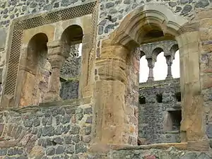 Münzenberg Palace has walls of rubble but refined detailing in its windows, the triple arch of the door and the gallery seen beyond which opens onto a vista.