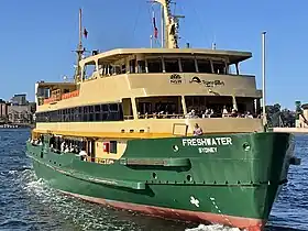 Freshwater departing Circular Quay in 2022, showing her modified open upper decks and window arrangements.