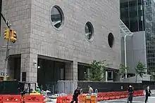 The bullseye windows on 56th Street as seen from across Madison Avenue. There are three bullseye windows on the second floor. Below them are openings for the sidewalk.