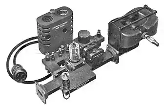 Transmitter assembly of a 20 kW, 9.375 GHz air traffic control radar, 1947.  The magnetron tube mounted between two magnets (right) produces microwaves which pass from the aperture (left) into a waveguide which conducts them to the dish antenna.