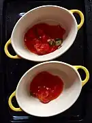 Casserole dish is layered with tomato sauce.