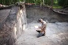 Archeologist writing in a journal while doing field work