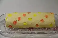 Rolled cake with orange and yellow dots over the surface