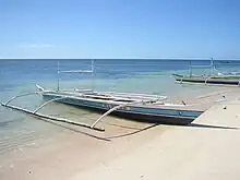 A small Philippine basnigan with the characteristic poles used for anchoring nets and holding gas-powered lamps for attracting fish