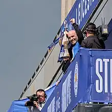 Enzo Maresca holds a silver trophy aloft