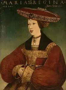 Mary wearing a dark brown dress and a tan head covering