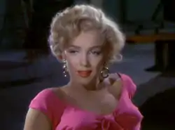 Monroe in Niagara. A close-up of her face and shoulders; she is wearing gold hoop earrings and a shocking pink top