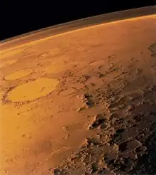 The southern rim of Argyre basin, formed by the Charitum Montes. Adjacent are sinuous ridges, theorized to be glacial eskers. The crater Galle is seen in the background.