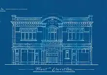 a dark blue background white line drawing of the front facade of a two story picture theatre with quite a few decorative details. Underneath the drawing in fancy printed handwriting 'Front Elevation'