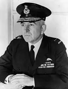 Informal half portrait of man in dark military uniform with peaked cap