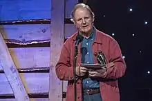 Michael Morpurgo on stage accepting an award.