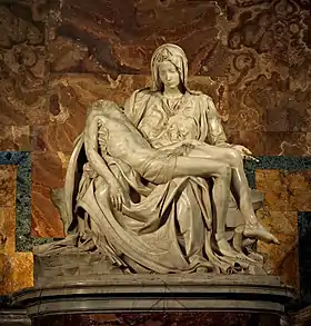 image of Michelangelo's famous sculpture the Pieta. Mary is seated looking at the body of her son draped across her lap.