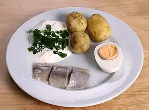 Pickled herring with sour cream, chives, potatoes and egg