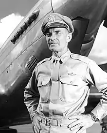 Harmon in uniform, standing in front of an aircraft