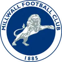 Millwall crest: a blue circle with a white border, in the centre is a white and grey lion, around the border are the words Millwall Football Club and the year 1885 in blue letters.